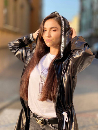 Długa, czarna kurtka parka EGY, zdobiona białym wykończeniem, zapinana na zamek z kapturem, wiązana w pasie.