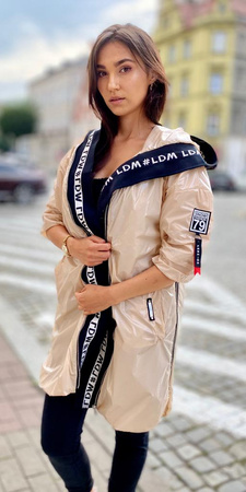 Długa, beżowa kurtka parka BEIGE NORBI, zdobiona czarnym wykończeniem, zapinana na zamek z kapturem.