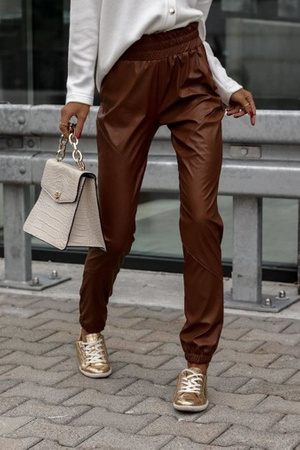 Brązowe długie spodnie damskie z imitacji skóry z ozdobnymi przeszyciami i ściągaczami przy nogawkach ELLA